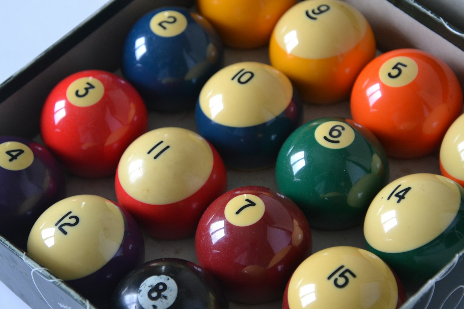 Close-up of numbered pool balls in a box.